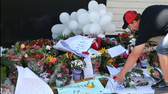 Um homem coloca flores em frente a boate Kiss em homenagem as vítimas da tragédia