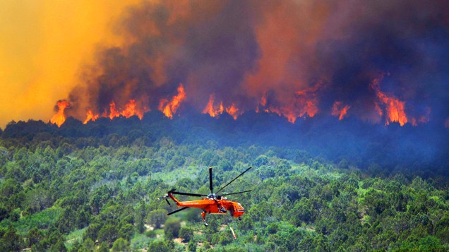 Helicóptero combate fogo no norte de Fairview, Utah. Mais de 500 imóveis estão ameçados pelo incêndio, forçando mais de 1.500 pessoas a deixarem suas casas