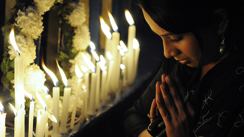 Ativista indiana reza após cerimônia de cremação do corpo de vítima de estupro