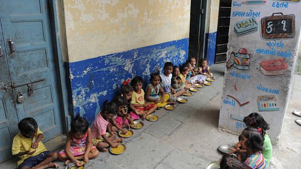 Crianças comem merenda escolar na Índia