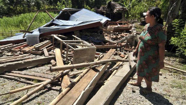 Mulher observa estrago causado por terremoto em Tovu, na Indonésia