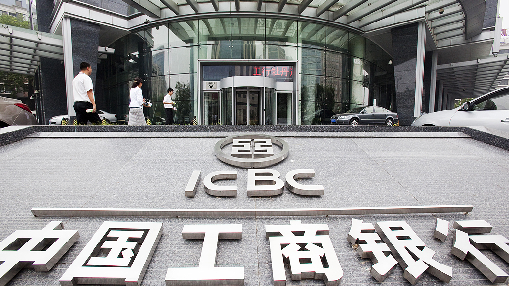 Pedestres passam por uma sucursal do Banco Industrial e Comercial da China (ICBC) Ltd., em Pequim