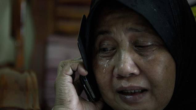 <p>Familiar de passageiros do voo da Malaysia Airlines, que desapareceu no Mar da China Meridional, chora ao telefone no Aeroporto Internacional de Kuala Lumpur, na Malásia</p>