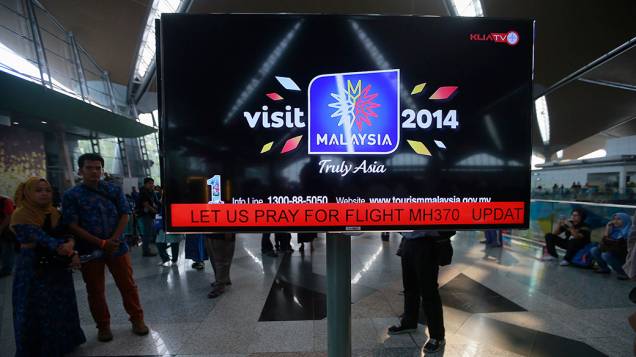 <p>Painel de informações no Aeroporto Internacional de Kuala Lumpur na Malásia, exibe uma mensagem "Oremos pelo voo MH370". O avião da Malaysia Airlines que transportava 239 passageiros de Kuala Lumpur para Pequim desapareceu no Mar da China Meridional </p>