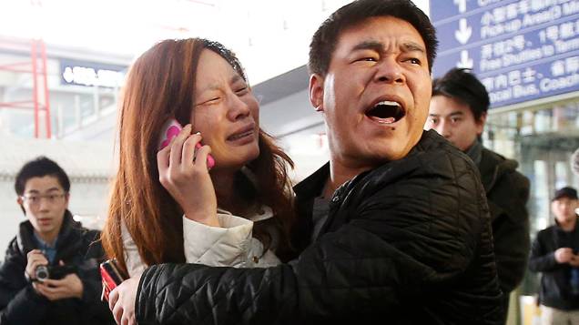<p>Mulher chora enquanto fala ao celular em busca de informações de um parente que estava no avião da Malaysia Airlines e desapareceu no Mar da China Meridional, no Aeroporto Internacional de Pequim</p>