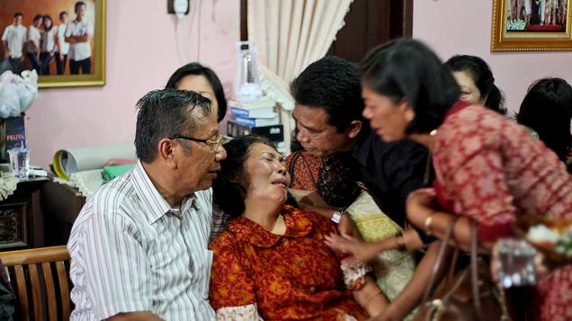 <p>Familiares de um cidadão indonésio que estava no voo da Malaysia Airlines que desapareceu sobre o Mar do Sul da China, em sua residência em Medan, na Indonésia</p>