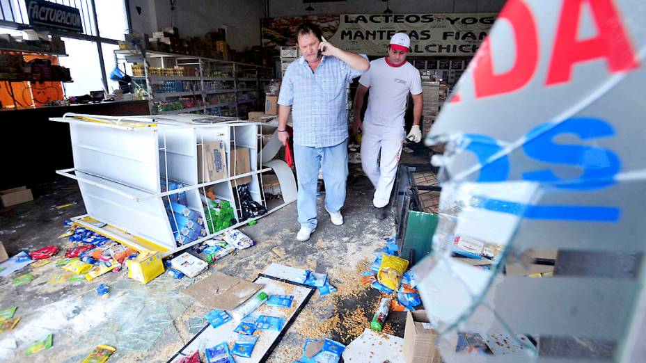 Dono de um mercado avalia os prejuízos após ter seu estabelecimento saqueado na província de Tucuman, na Argentina