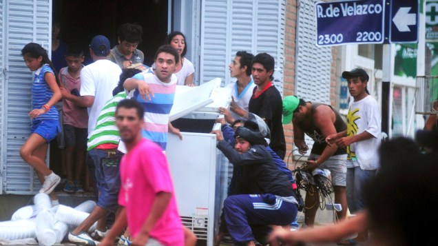 Pessoas carregam produtos após saquearem um mercado na província de Tucuman, na Argentina