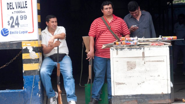 Funcionários de um mercado se armam para proteger um estabelecimento na província de Tucuman, na Argentina