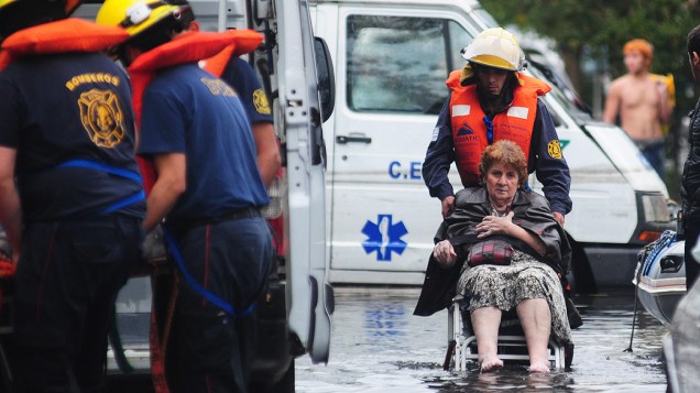 Mulher é resgatada por bombeiros em rua inundada devido as fortes chuvas que atingiram La Plata nos últimos dias, na Argentina