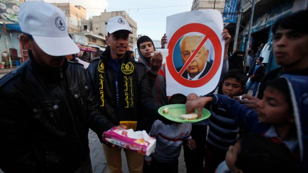 Palestinos celebram a morte morte do ex-primeiro-ministro israelense Ariel Sharon, em Khan Youni, ao sul da faixa de Gaza