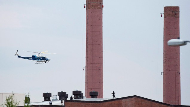 Um helicóptero da polícia sobrevoa o telhado de um edifício em resposta a um tiroteio no Arsenal de Marinha de Washington, nesta segunda-feira (16)