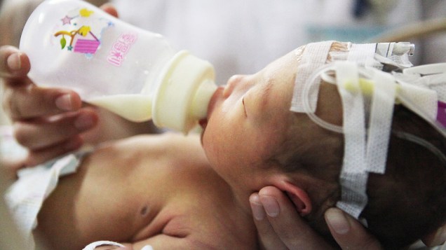 A enfermeira alimenta o bebê, que havia sido resgatado de tubulação de esgoto em um prédio residencial em um hospital em Jinhua, província de Zhejiang, leste da China