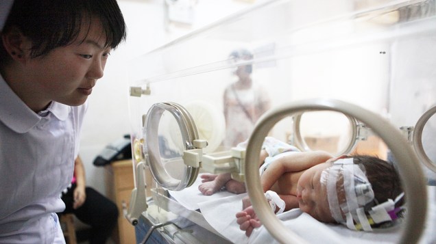 A enfermeira alimenta o bebê, que havia sido resgatado de tubulação de esgoto em um prédio residencial em um hospital em Jinhua, província de Zhejiang, leste da China