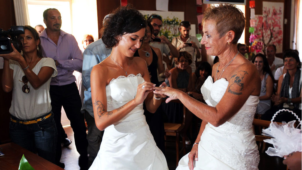 Corinne Denis e Laurence Cerveaux trocam alianças como parte de sua cerimônia de casamento em Saint-Paul de la Reunion, durante o primeiro casamento gay na ilha francesa de La Reunion