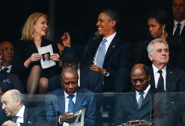 Presidente Barack Obama brinca com a primeira-ministra da Dinamarca, Helle Thorning Schmidt, durante à cerimônia religiosa de despedida de Nelson Mandela, nesta terça-feira (10)