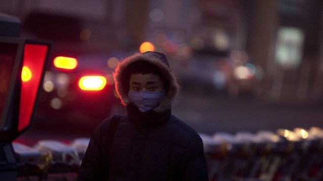 Homem usa máscara enquanto caminhava pela rua em Pequim, China