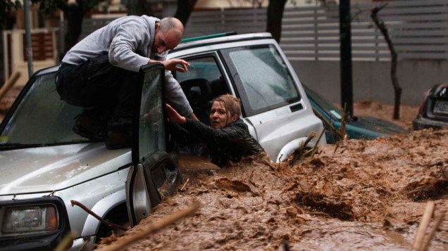 Mulher presa em seu carro é resgatada por morador durante inundação no subúrbio norte de Atenas