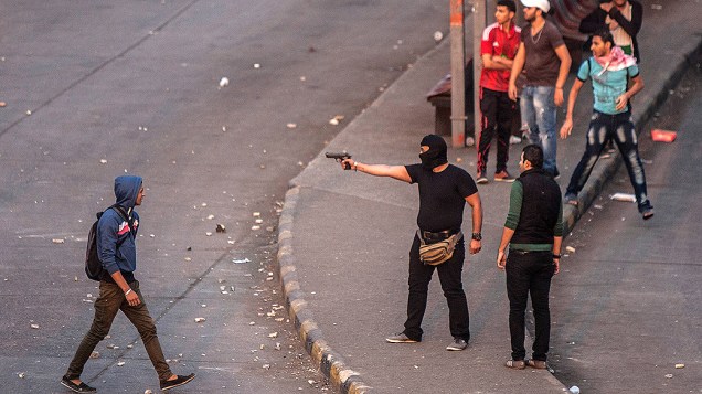 Manifestante mascarado aponta uma arma durante protestos que lembram o aniversário dos atos de 2011 quando dezenas de manifestantes foram mortos nos arredores da Praça Tahrir, no Cairo, após a queda do então presidente Mubarak - (19/11/2013)