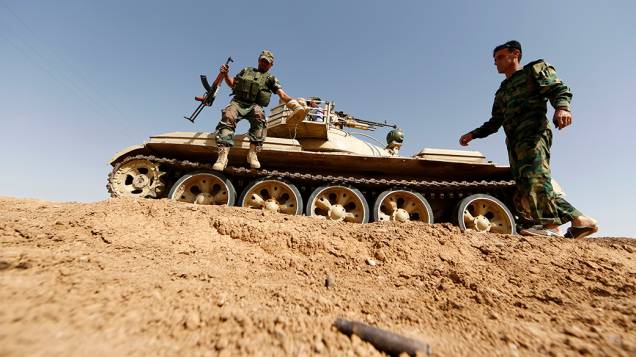 Membros das forças curdas Peshmerga mantém posição na aldeia iraquiana de Basheer; Militantes sunitas liderados pelo Estado Islâmico do Iraque e do Levante assumiram o controle de uma passagem de fronteira Iraque-Síria depois que os rebeldes sírios se retiraram durante a última madrugada