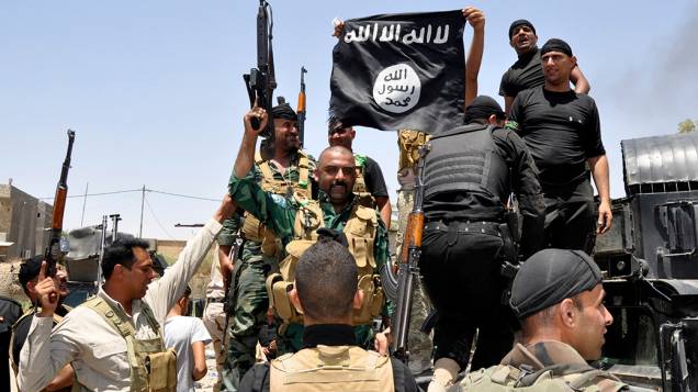 Forças de segurança iraquianas destroem a bandeira do grupo militante sunita pertencente ao Estado Islâmico do Iraque e do Levante (EIIL), durante uma patrulha na cidade de Dalli Abbas; O líder da Al Qaeda pediu aos muçulmanos de todo o mundo para pegarem em armas e migram para o Estado declarado em solo sírio e iraquiano