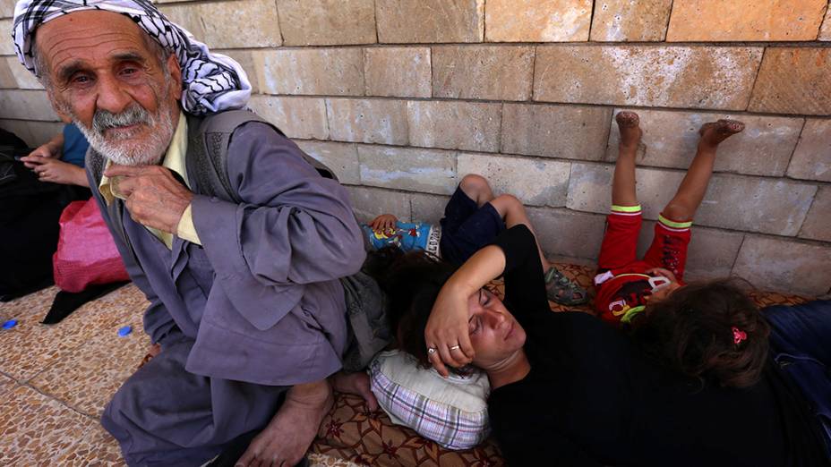 Cristãos iraquianos que fugiram da violência na aldeia de Qaraqush, a leste da província de Nínive, descansam na igreja São José, na cidade curda de Erbil, na região autônoma do Curdistão iraquiano