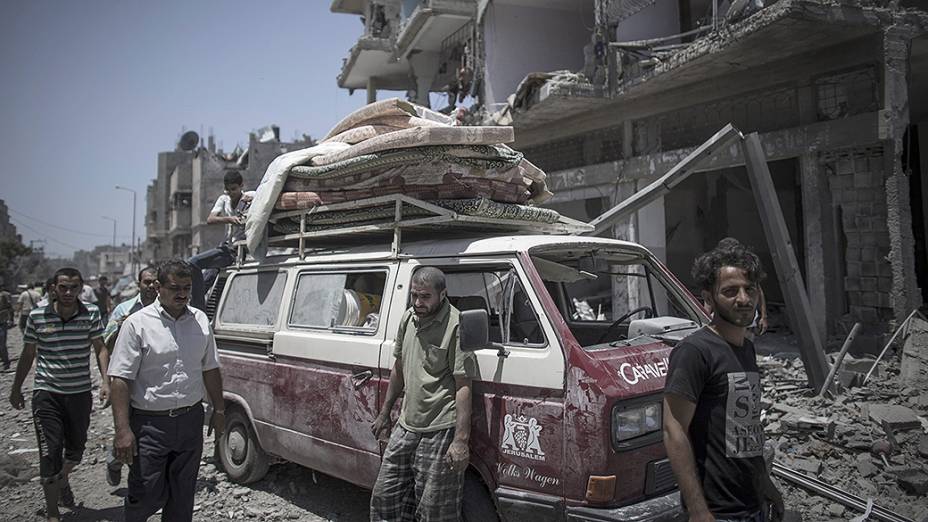 Palestinos tentam recuperar objetos em meio aos escombros no bairro Shujaiyya no leste da Cidade de Gaza