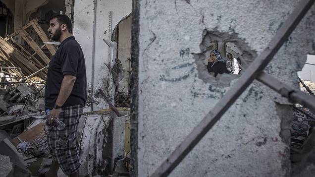 Palestino procura por pertences em sua casa destruída por um míssil isralenses, na Faixa de Gaza