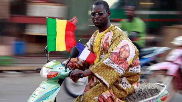 Em Bamako, motociclista anda com as bandeiras do Mali e da França