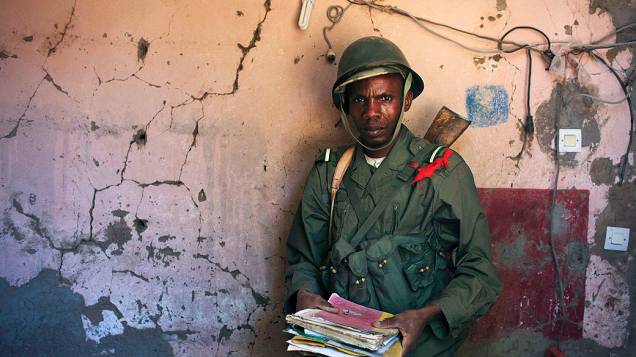 Soldado malinês segura documentos encontrados nos escombros de um acampamento militar em Diabaly