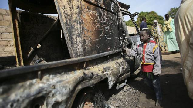 Criança observa veículo usado por terroristas e destruído por tropas francesas na cidade de Diabaly, Mali