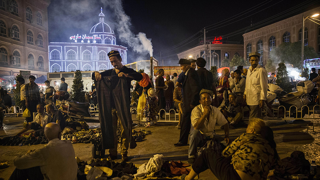 Centenas de uigures se reúnem durante a noite em uma praça, na cidade de Kashgar, localizada na província autônoma de Xinjiang, ao noroeste da China