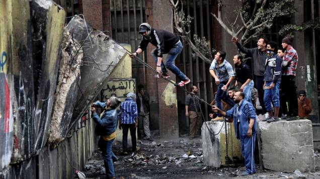 Manifestantes egípcios tentam derrubar um muro construído para impedi-los de chegar ao Parlamento e ao prédio do Gabinete perto da Praça Tahrir no Cairo, Egito 24 de janeiro de 2013