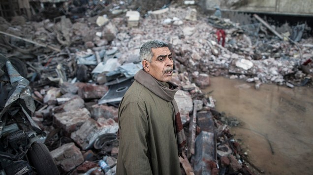 Homem fotografado em meio ao local onde uma bomba destruiu um prédio da polícia na cidade egípcia de Mansura, ao norte da cidade do Cairo - (24/12/2013)