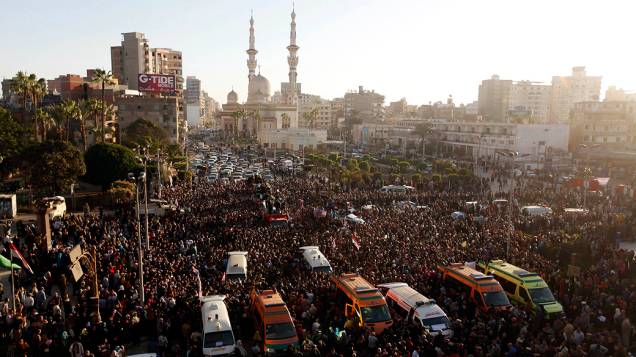 Egípcios participam do funeral das vítimas de um ataque a bomba que destruiu um prédio da polícia na cidade egípcia de Mansura, ao norte da cidade do Cairo - (24/12/2013)
