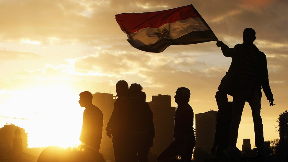 Manifestante conduz bandeira egípcia na ponte Kasr El Nile, Cairo