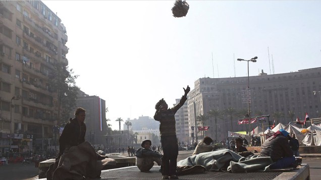Crianças brincam em uma saída de ar da praça Tahrir, Cairo