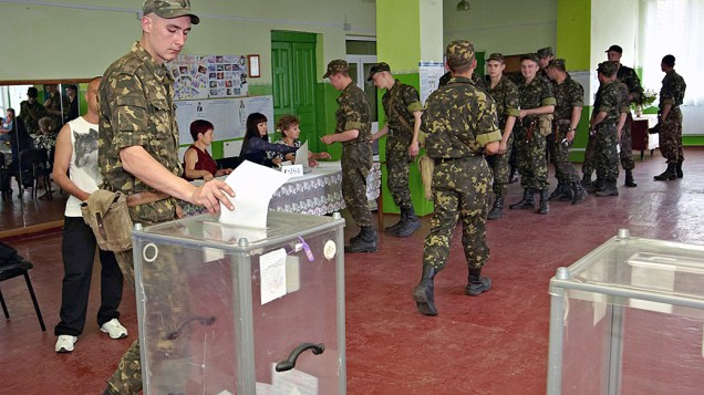 Soldado ucraniano lança seu voto durante as eleições presidenciais em uma assembleia de voto na cidade de Izyum, região Kharkiv, na fronteira com a auto-proclamada república Donetsk