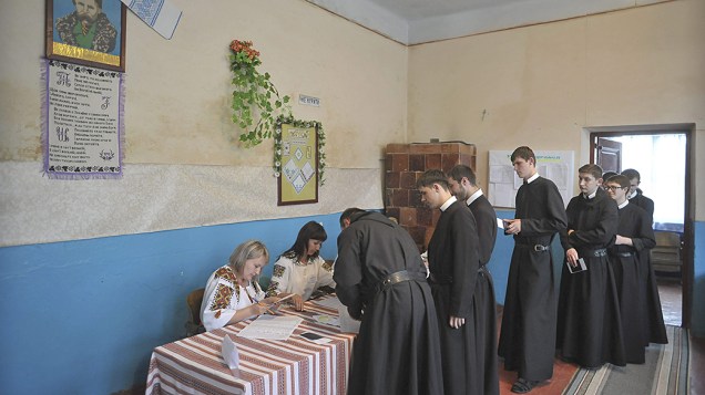 Padres participam das eleições presidenciais em um posto de votação na cidade de Lviv