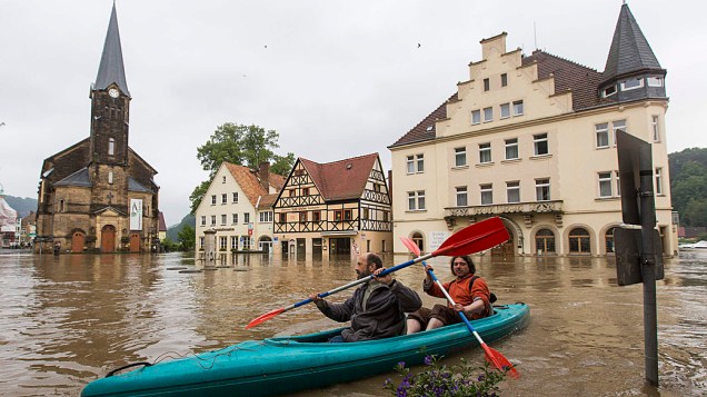 Dois homens de remo em uma praça do mercado inundado após o rio Elba romper suas margens durante uma enchente na Alemanha