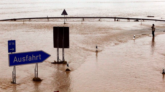 Homem anda em auto-estrada inundada, que se estende a partir de Munique para Salzburg, perto Grabenstaett, Alemanha