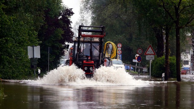 Fazendeiro dirige seu trator em uma estrada inundada perto Grabenstaett, na Alemanha