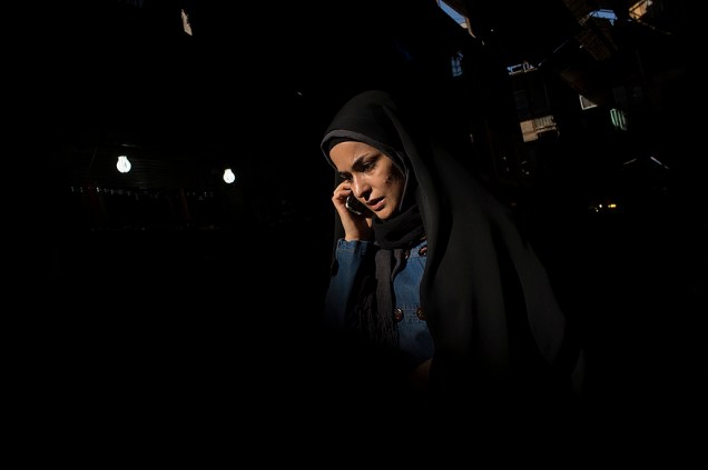Mulher fala no celular no mercado de Teerã, no Irã