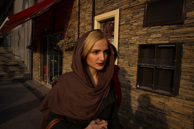 Mulher caminha em um bairro nobre da cidade de Teerã, onde as leis sobre as vestimentas estão mais liberais, no Irã