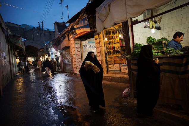 Mulheres vestidas com roupas conservadoras adam em um mercado, na cidade de Qom no Irã