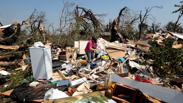 Mulher revira escombros de casa destruída por tornado em Oklahoma