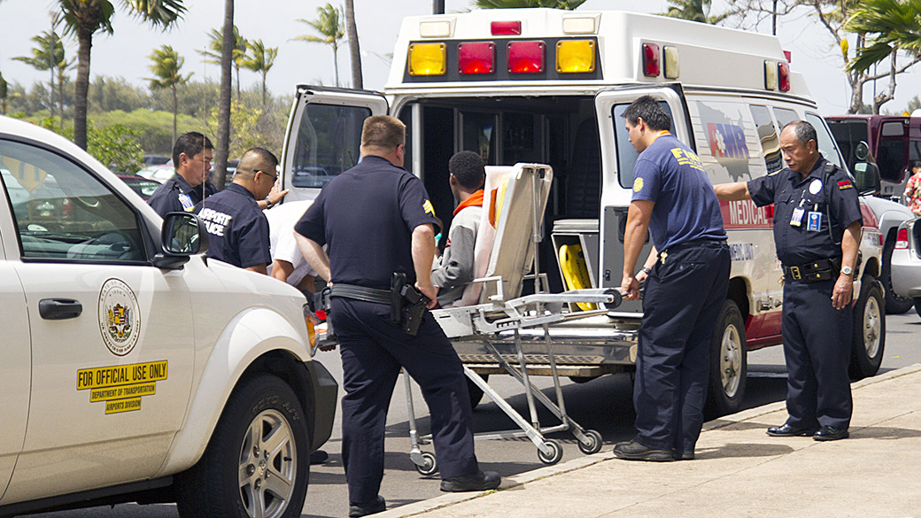 Menino de 16 anos é levado para uma ambulância após viajar 5 horas no trem de pouso de um avião, no Havaí