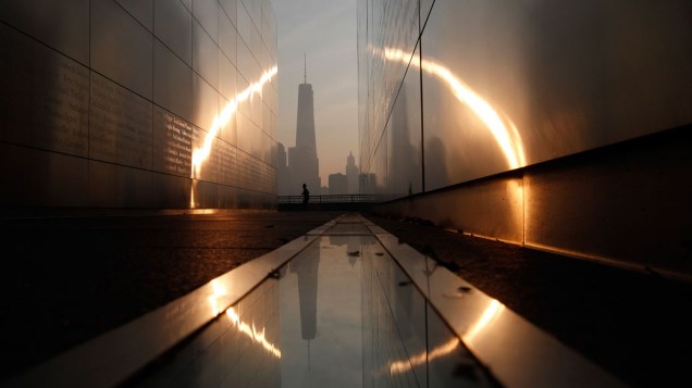 Ao amanhecer, homem passa pelo Memorial 11 de Setembro, em Nova York, durante cerimônia em homenagem às vítimas dos atentados de 2001