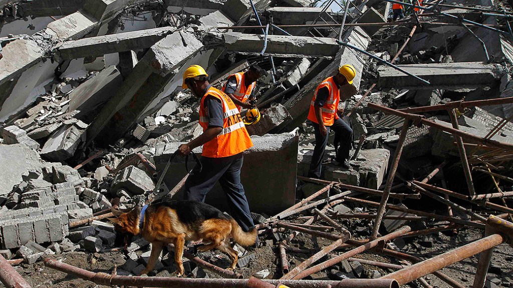 Equipes de resgate buscam por sobreviventes no local do desabamento de um edifício de onze andares que estava em construção na cidade de Chennai, na Índia