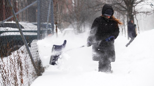 <p>Mulher usa uma pá para limpar neve de sua calçada, em Detroit, Michigan</p>